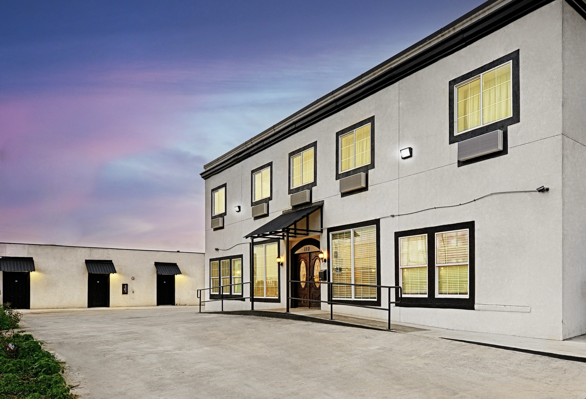 Hotel Dilley Grand at dusk, renovated two-story hotel exterior, 110 S Main St, Dilley, Texas