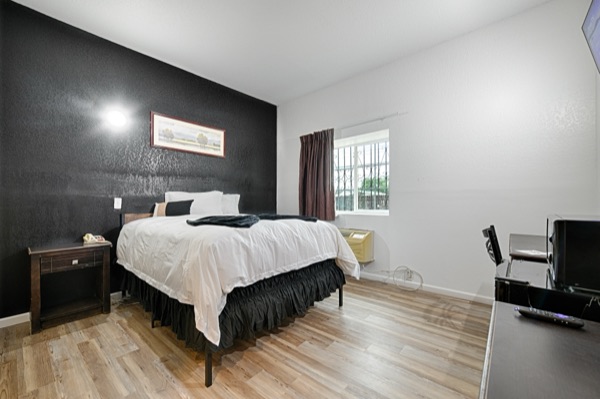 Queen bed with nightstand, TV and window light