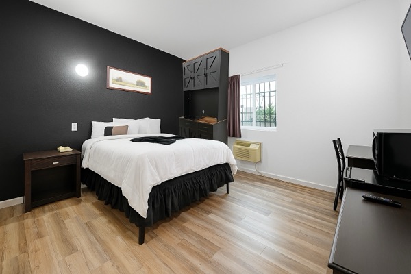 Queen room with black feature wall and workspace