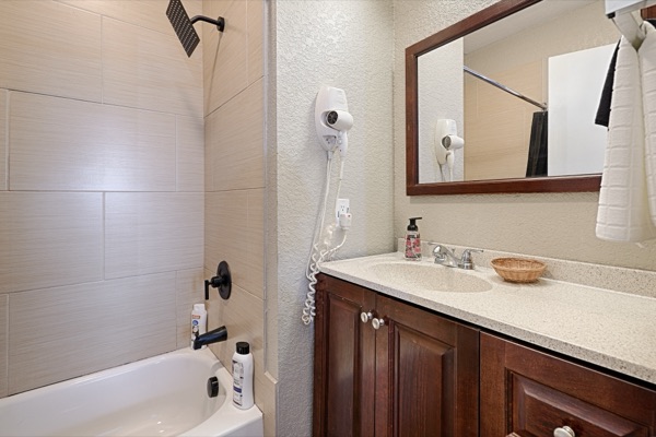 Renovated bathroom with tiled shower and wood vanity